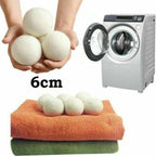 Reusable Wool Dryer Balls held in two hands showing 6cm size