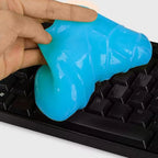 Close-up of blue cleaning gel being pressed onto keyboard keys