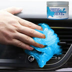 Hand pressing blue cleaning gel into a car air vent, with the product jar shown