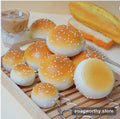 Realistic sesame bun squishy toys with keychain rings on a wooden tray | Snagworthy.store