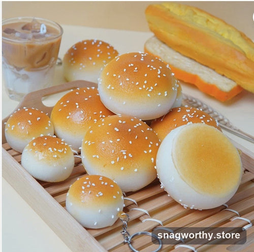 Realistic sesame bun squishy toys with keychain rings on a wooden tray | Snagworthy.store