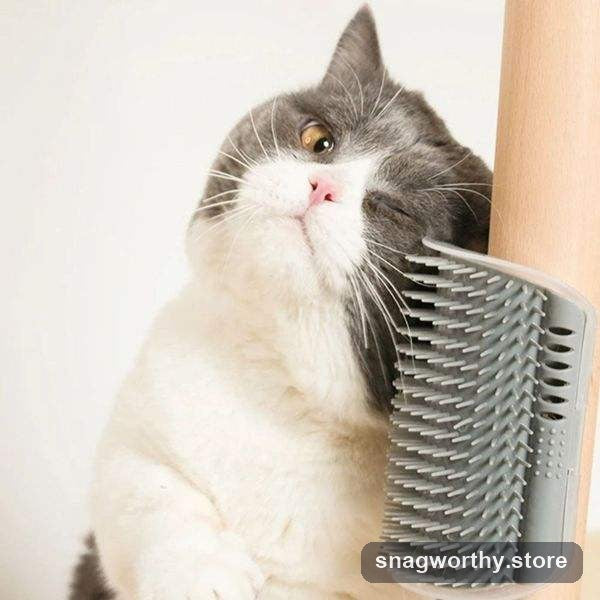 Grey and white cat rubbing its face against a wall-mounted corner self-groomer brush | Snagworthy.store