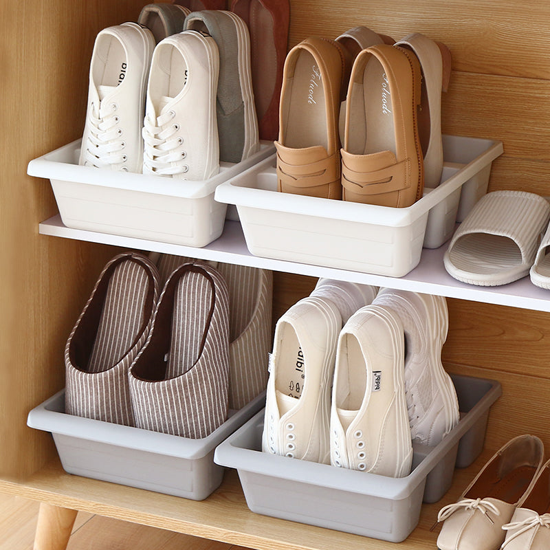 Clear stackable shoe storage boxes stacked in a closet
