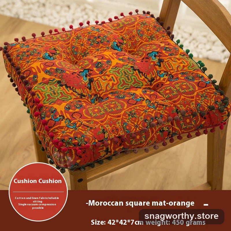 PlushSit tufted floor cushion in orange on a wooden chair, close-up | Snagworthy.store