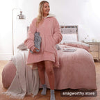 SnugDen oversized hooded blanket hoodie in pink, seated view | Snagworthy.store